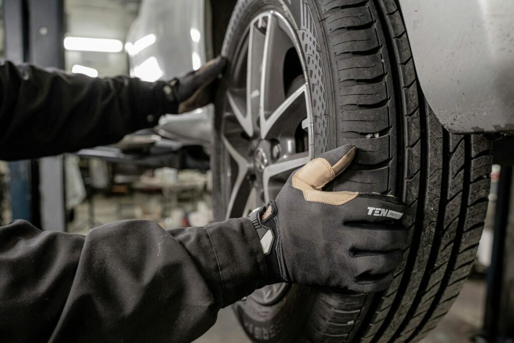Technician changing a tire on a vehicle in a shop